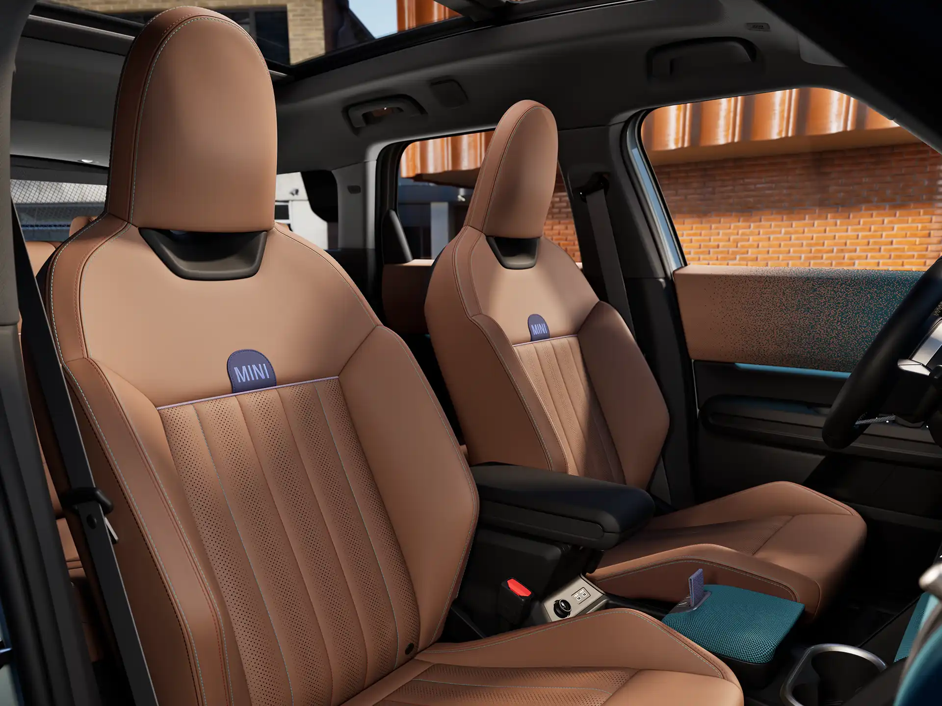 Interior perspective of the MINI Countryman showing the dashboard, steering wheel, round display, panorama glass roof and back of the front seats.