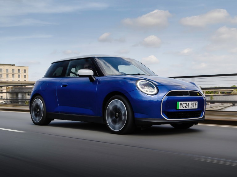 All-electric MINI Cooper driving down a road