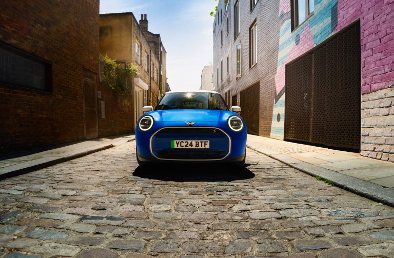 all-electric MINI Cooper front shot buildings on each side